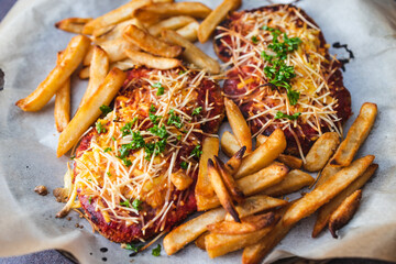 plant-based food, vegan plant-based schnitzel parmi with tomato and dairy-free cheese topping with...