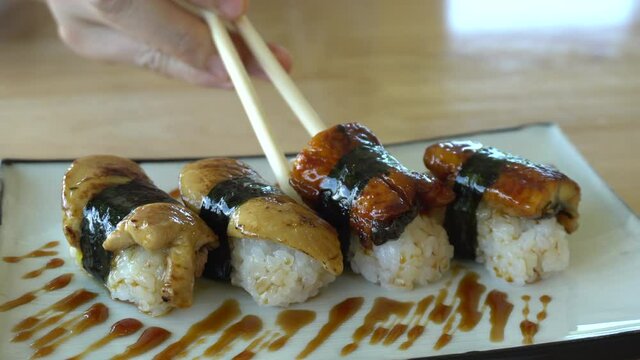 Chopsticks eating Sea eel and foie gras nigiri sushi Japanese fushion plate