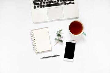 Top view of laptop, notebook, pen, phone, and coffee on white background
