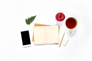 Top view of workspace with phone, coffee, and apple on white background