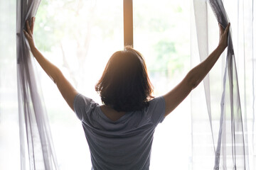 The woman woke up early. She stood at the window in her bedroom and she lifted up both arms to...