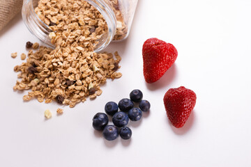 Strawberries and blueberries with and a bowl with granola