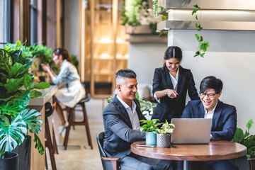Group of professional business discussing meeting strategy sharing ideas thoughts with project.Creative business people working with laptop computer in green plant terrace decorated modern workloft