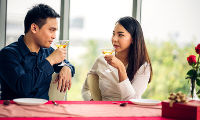Romantic young happy couple relax talking and drinking wine glasses celebrate together in the restaurant