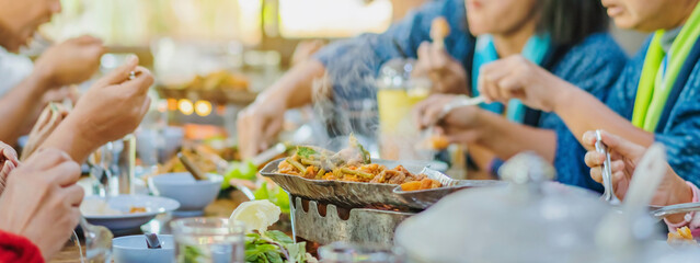 Group of female friends enjoy eating with acacia pennata omelette sour soup in fish shape hot pot in the restaurant. Selective focus.