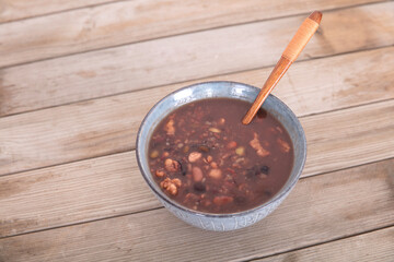 Prepared Laba porridge in a bowl on a shabby wooden background