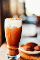 Iced cocoa drink  with whipped cream and Brownie cookies on wood table.