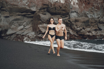 couple relaxing at a secluded private beach in Bali Indonesia. couple showing affection on a hidden beach. Couple wearing bathingsuits