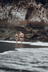 couple relaxing at a secluded private beach in Bali Indonesia. couple showing affection on a hidden beach. Couple wearing bathingsuits