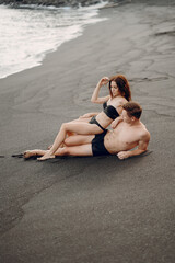 couple relaxing at a secluded private beach in Bali Indonesia. couple showing affection on a hidden beach. Couple wearing bathingsuits