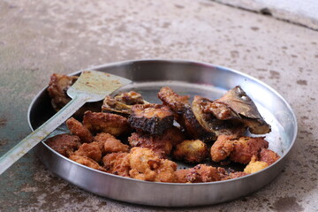 Indian food is being prepared with clay stoves, firewood, ash on the floor.