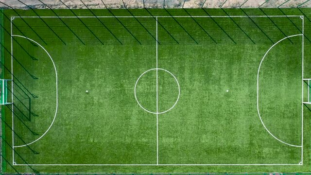 Aerial view of a soccer field in a public park. View from a drone of a green football field. Top view.