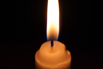 Macro photo of a single candlelight burning in the dark, extreme close up photo of a candle in the night.