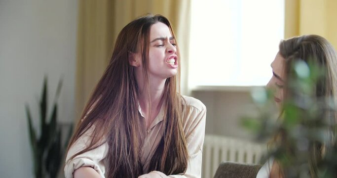 Two young women fighting over parcel, cannot split the purchase. Sisters receive delivery from online store service, sale discounted on Black Friday, unpack box, feel greedy quarrel, compete for gift