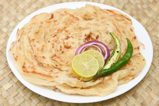 Indian flat bread Kerala porotta, Malabar porotta, paratha layered bread made of whole wheat flour or Maida, India. chapathi, fulka, parantha ,rumali roti served with side dish  meat curry.
