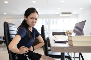 Asian girl suffering from abdominal pain,chronic inflammation of stomach or gastritis caused by...