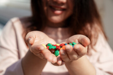 Colourful Chocolate candies in dessert lover hands.