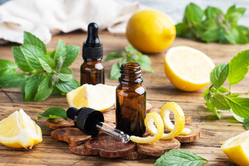 Lemon citrus fruit essential oil and mint, aromatherapy oil natural organic cosmetic on rustic wood background.