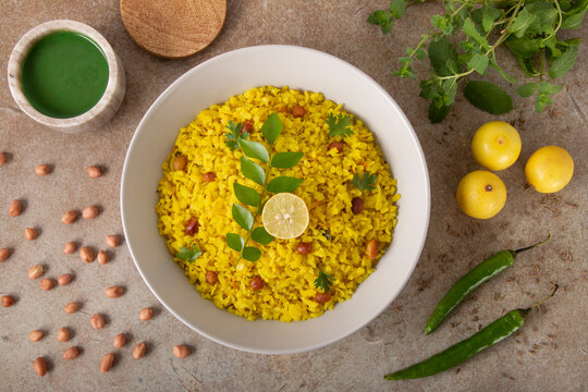 Traditional Indian Flattened Rice Breakfast also known as Poha served in a bowl along with spicy Mint Chutney