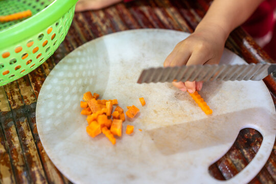 Asian School Kids Learn To Cut Vegetable In Cooking Class Closeup