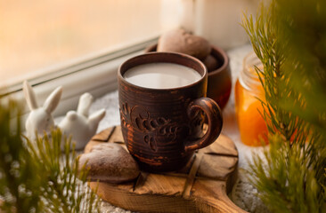 Obraz na płótnie Canvas breakfast on the windowsill: a mug with cocoa and orange jam and easter bunny