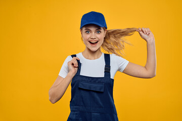 Woman in working uniform blue cap delivering courier service yellow background