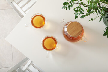 White kitchen table with tea and plant