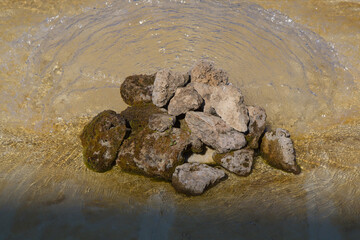 Stones covered with moss piled in clear water