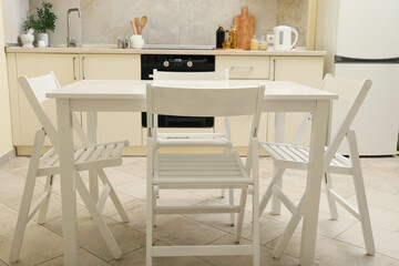 Kitchen interior with wooden table and folding chairs
