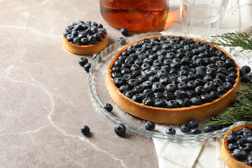 Fototapeta na wymiar Concept of tasty lunch with blueberry pie on gray table