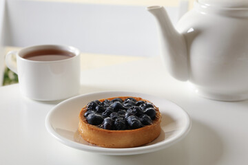 Concept of breakfast with blueberry pie on white table