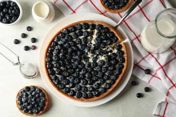 Concept of tasty lunch with blueberry pie on light background