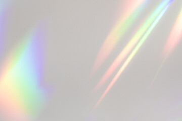 Blurred rainbow light refraction texture overlay effect for photo and mockups. Organic drop diagonal holographic flare on a white wall. Shadows for natural light effects