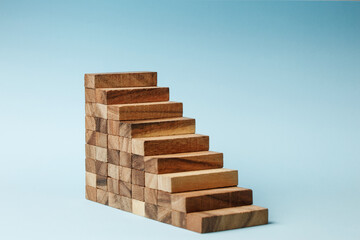 Stairs of wooden blocks on blue background.