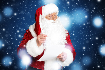 Santa Claus making list of gifts against color background