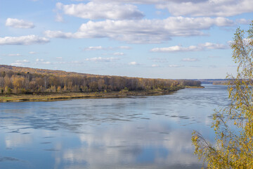 Beautiful, wide river autumn among the woods.