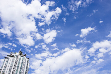 White cloud in clear blue sky background. With little building condominium.