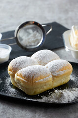 Fresh butter bread on a plate sprinkled with icing sugar