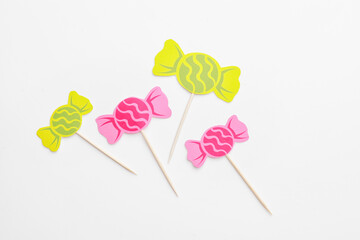 Stylish cupcake toppers on white background
