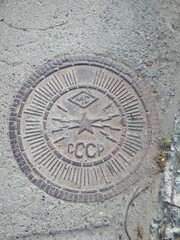 Fototapeta na wymiar CCCP manhole metal cover stone street city