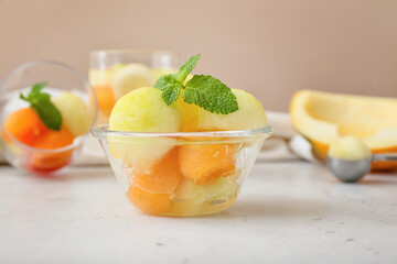 Bowl with tasty melon balls on table
