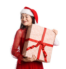 Happy young woman in Santa hat and with Christmas gift on white background
