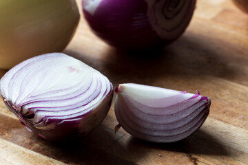 Makroaufnahme einer roten Zwiebel auf einem Holzbrett