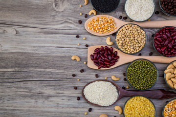 Obraz na płótnie Canvas Cereal grains seeds beans on wooden background. Whole grains and bean. Cereals and beans. Different dry legumes for eating healthy