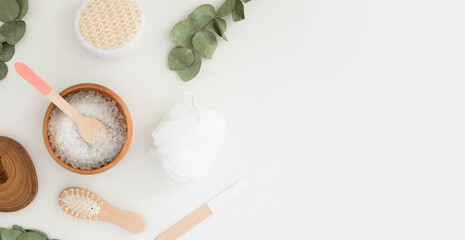 Beauty spa set flat lay with salt, eucalyptus and wooden accessories over white background