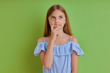 thoughtful caucasian teen girl ism in contemplation, drowned in thoughts. isolated green background