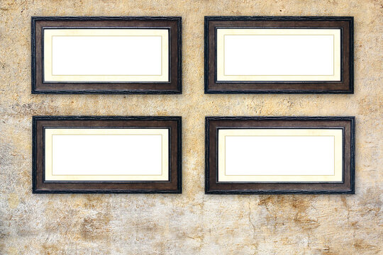 Four empty picture frames on old stucco wall