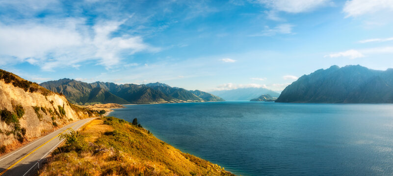 Lake Hawea Panorama in beautiful morning light with mountain peaks in the distance in Mount Aspiring National Park, Otago Region, New Zealand, Southern Alps.