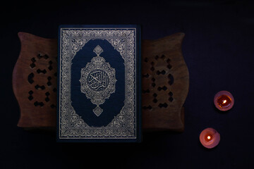 Quran in the mosque - open for prayers The black background of the Muslims around the world placed on a wooden board Quran in the mosque - open for prayers