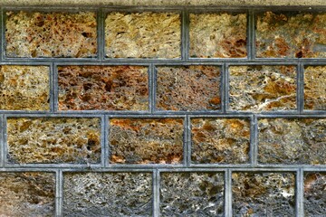 A wall made up of bricks looks like spoiled ice cream in containers got attacked by fungus and bacteria